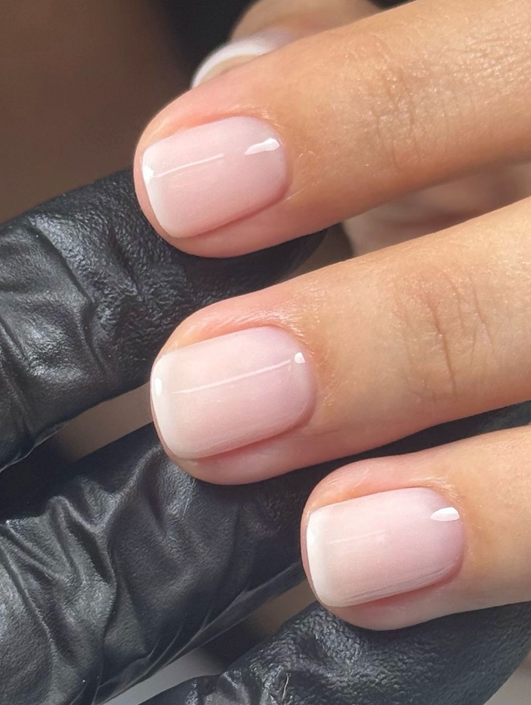 Close-up of a soft milky French manicure on short natural nails